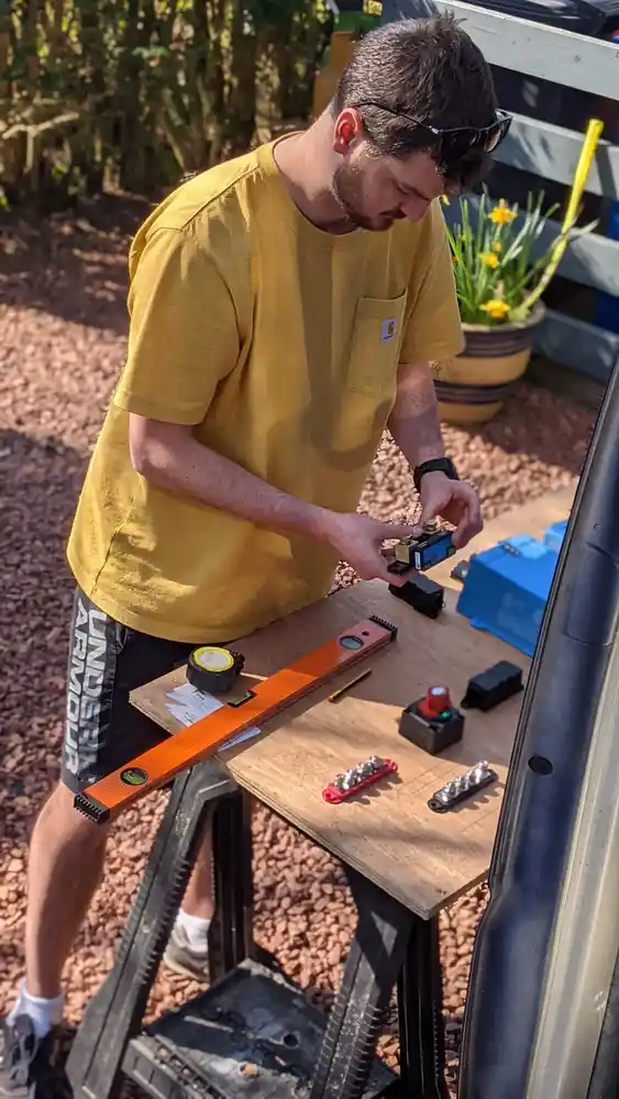 Alan Heffernan assembling campervan electrical components at a workbench
