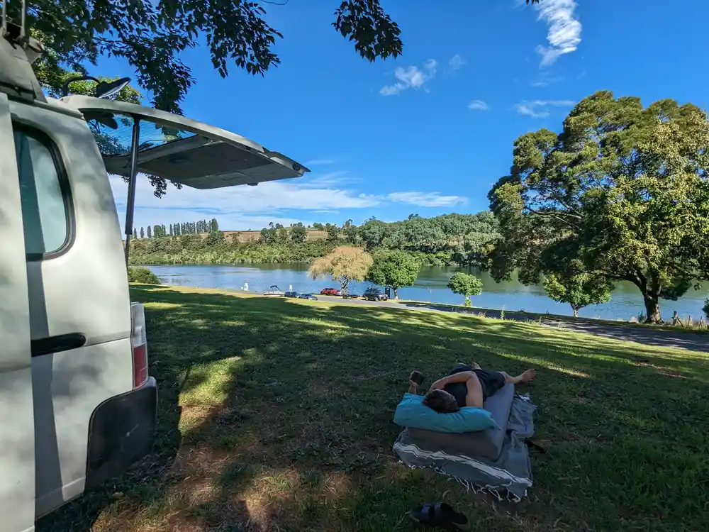 Toyota Hiace campervan parked lakeside with off-grid setup