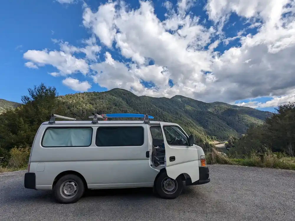 Toyota Hiace with surfboard on roof rack in the mountains